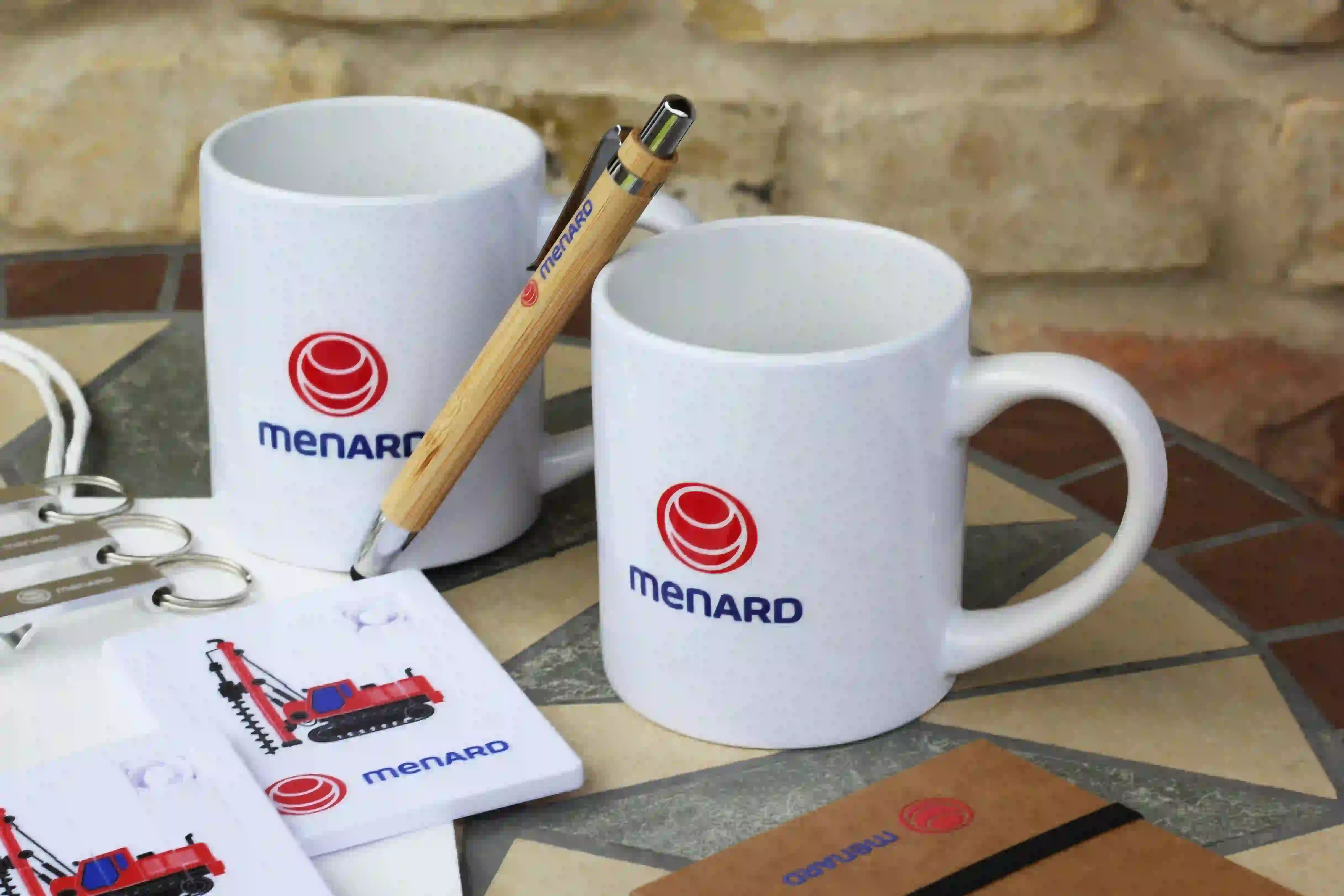 Biele hrnčeky s potlačou a ďalšie reklamné predmety s firemným logom Medard.