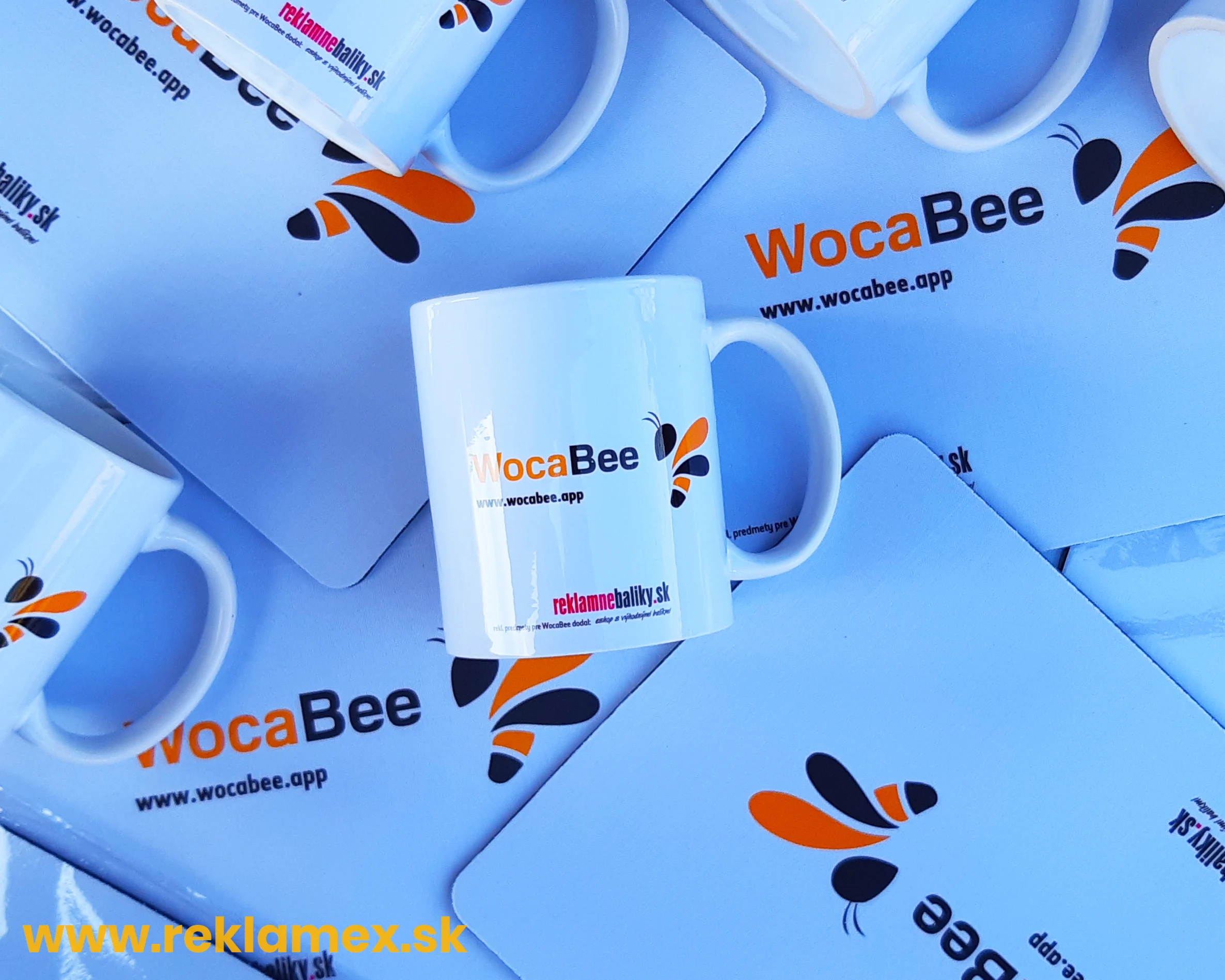 Biele reklamné predmety s plnofarebnou potlačou loga - na fotka je fotografia hrnčeka s potlačou a podložky pod myš s potlačou loga.