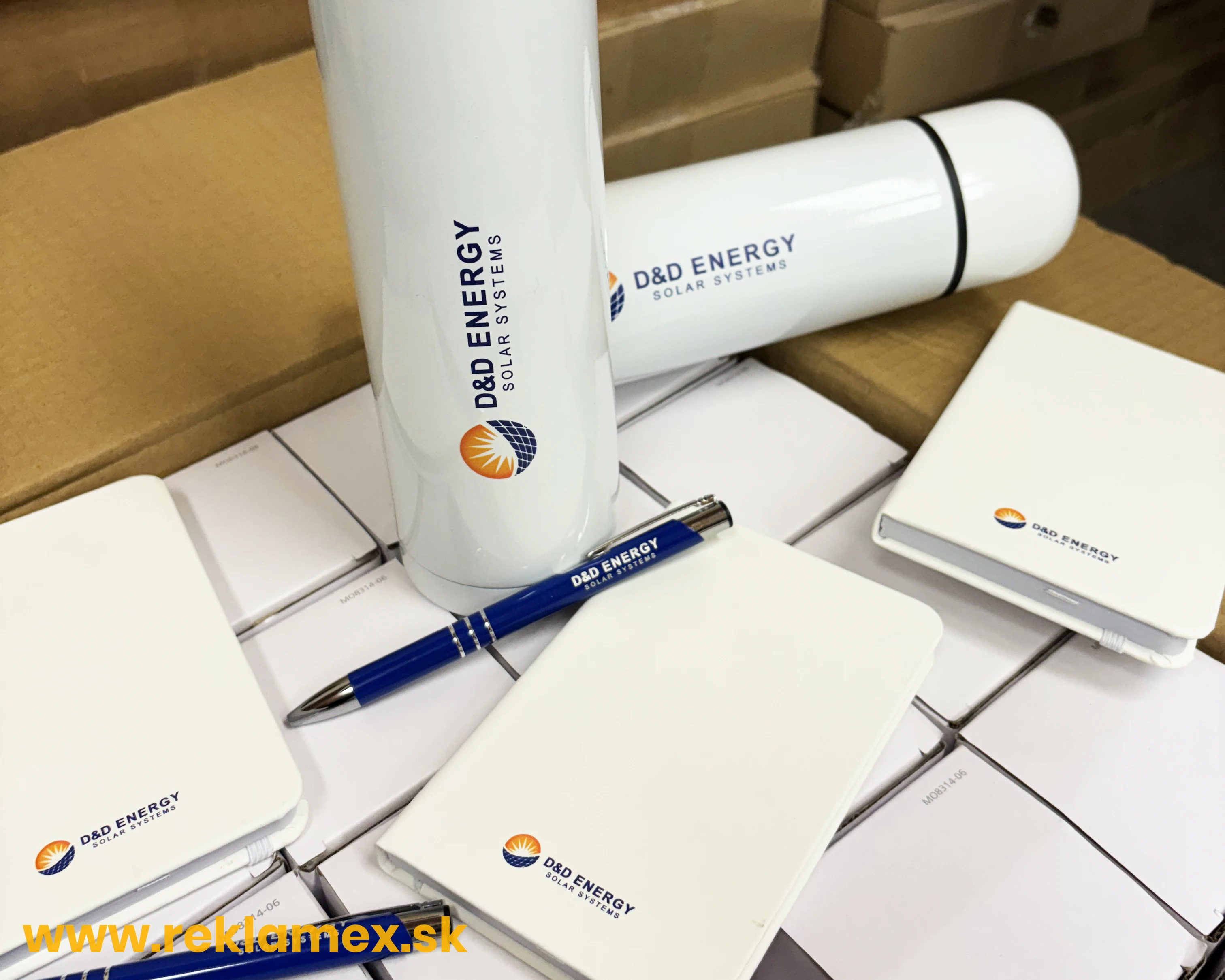 Reklamné oranžové termosky a perá s logom 